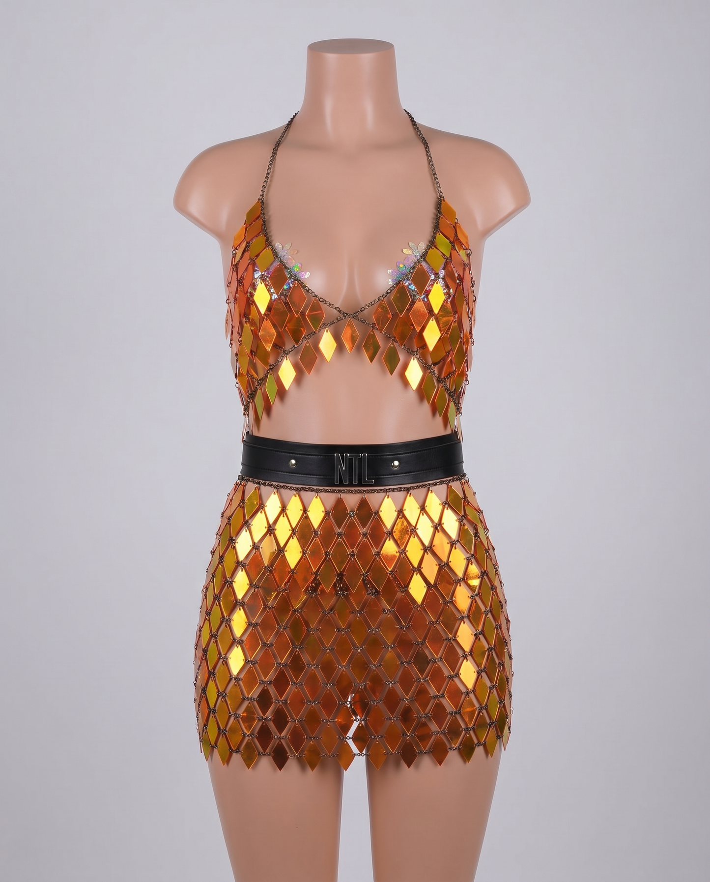 Holographic orange mirror crop top and skirt festival outfit on mannequin