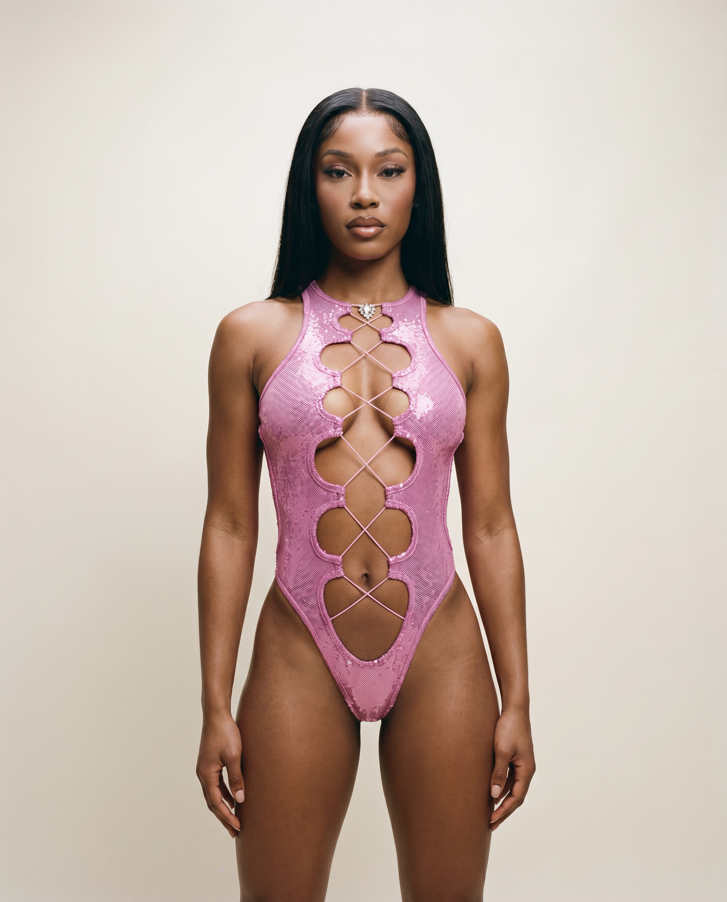 Woman in a sparkly pink cutout bodysuit, festival and rave fashion on neutral background