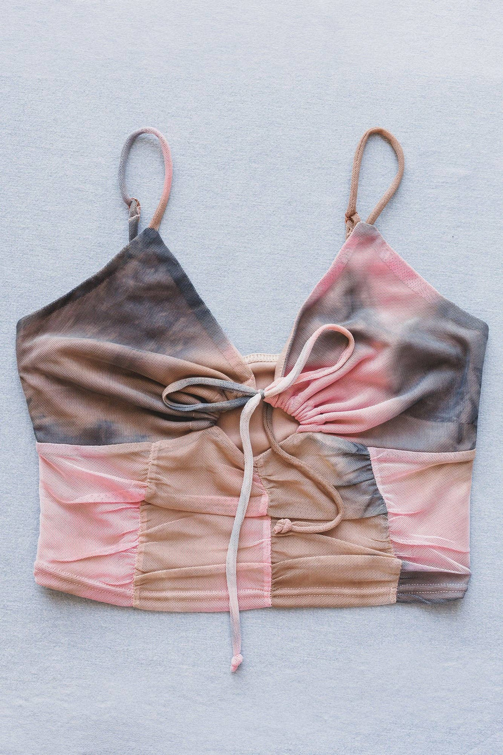 Gradient bikini top with pink, brown, and gray colors on a light gray background