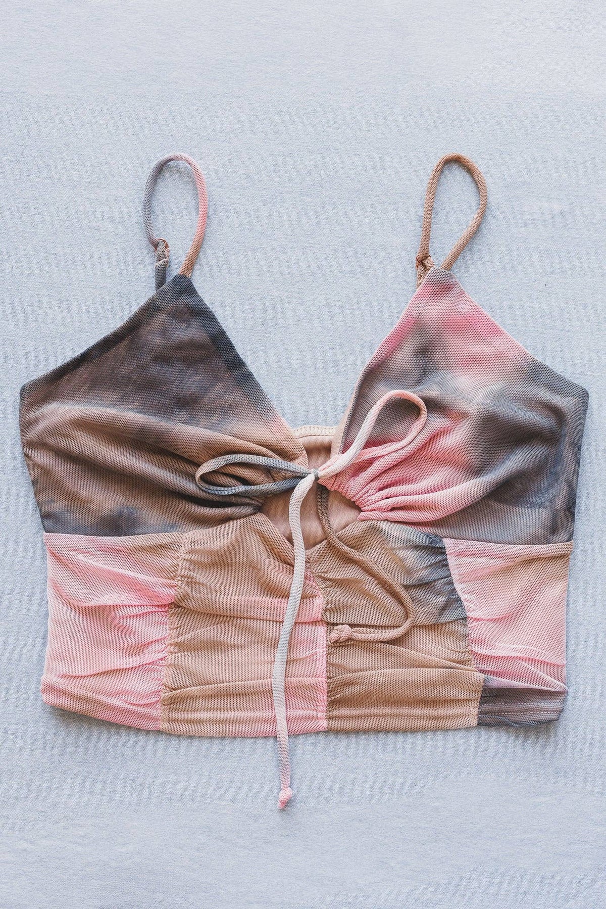 Gradient bikini top with pink, brown, and gray colors on a light gray background