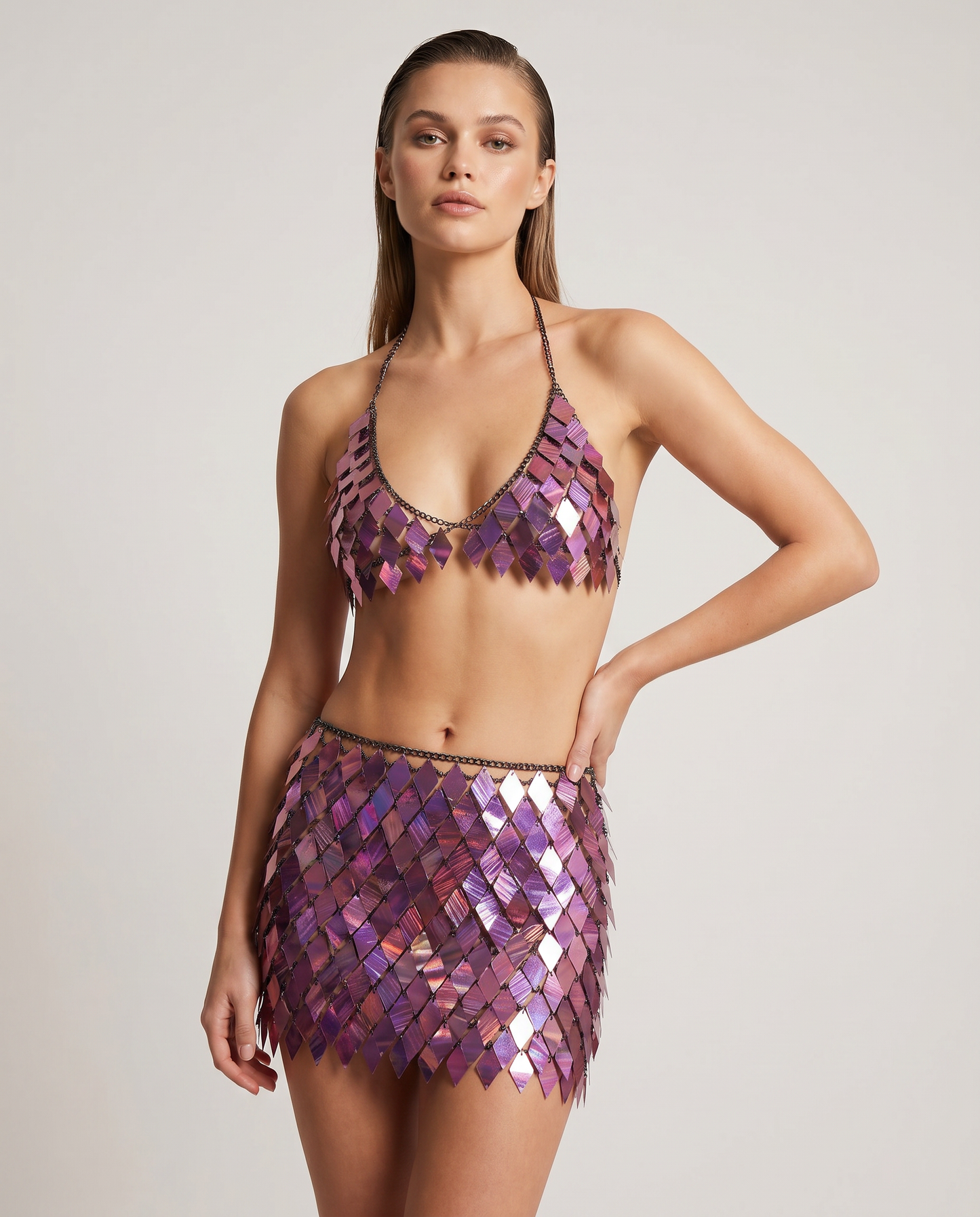 Woman wearing a prismatic purple sequin festival crop top and mini skirt set