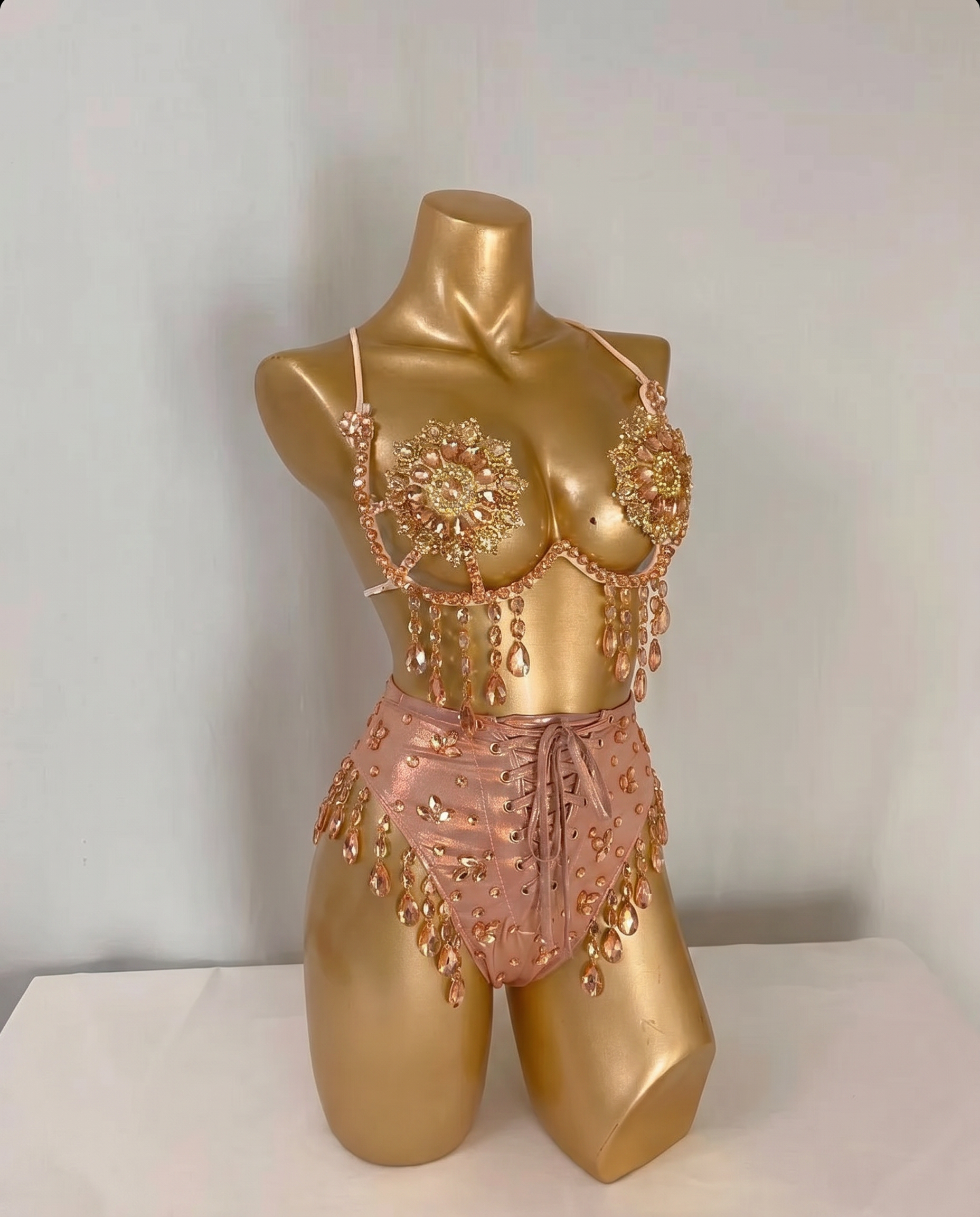 Mannequin displaying embellished pink festival bra and high-waist shorts with rhinestones