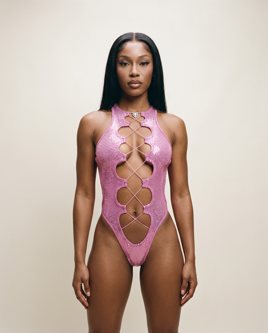 Woman in a sparkly pink cutout bodysuit, festival and rave fashion on neutral background