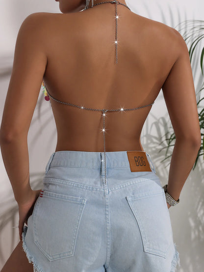 Y2K-inspired, backless festival look with prismatic high-refraction crystal chain, high-rise denim shorts