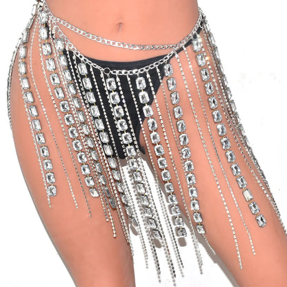 Prismatic Y2K-inspired rhinestone-embellished crystal fringe chain skirt, high-refraction, rave-ready.