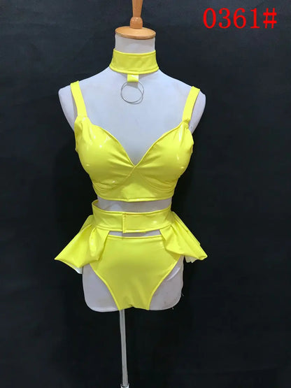 High-visibility yellow festival two-piece with body-contouring technology and UV-reactive aesthetic for main stage sets.