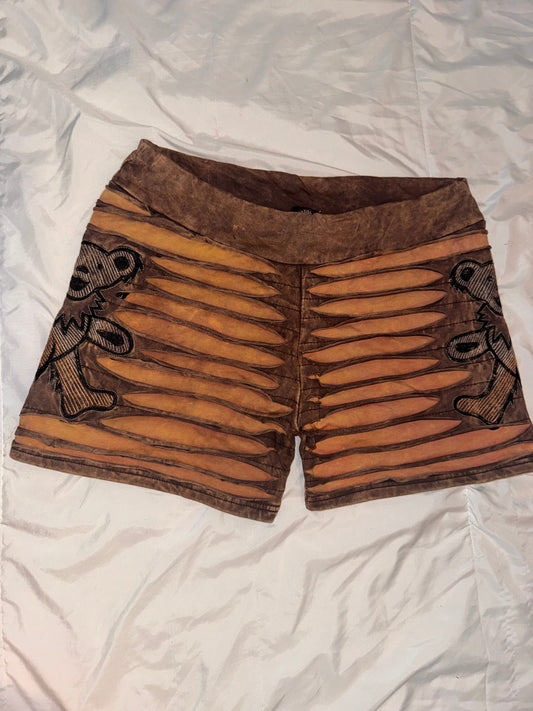 Pair of brown corset-like garments with decorative patterns on a white fabric background