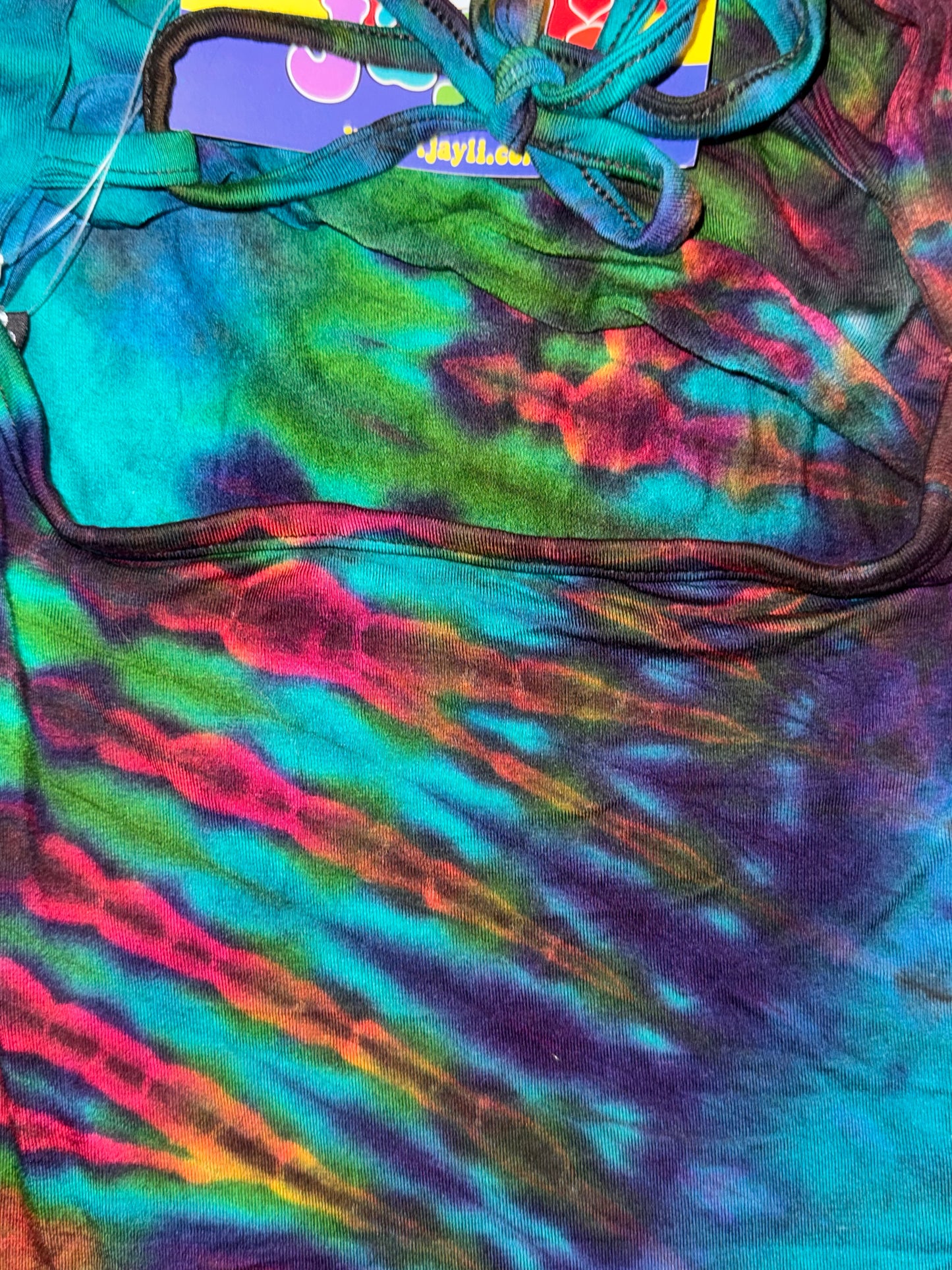 Colorful tie-dye pattern on a garment with a brand label.